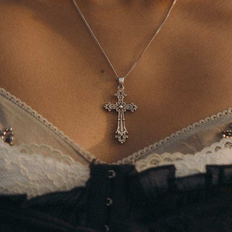 Ornate gothic cross pendant necklace in oxidised sterling silver with carved arm detail, worn on a fine box chain.