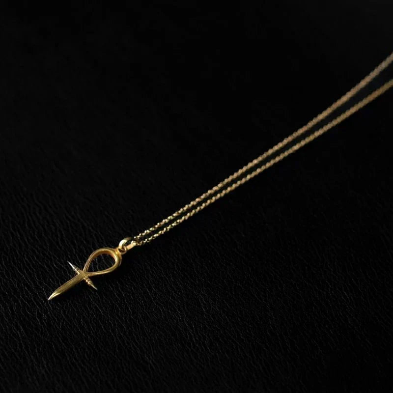 Ankh pendant necklace in 22K gold plated over 925 sterling silver on a delicate chain, resting at the collarbone against bare skin.