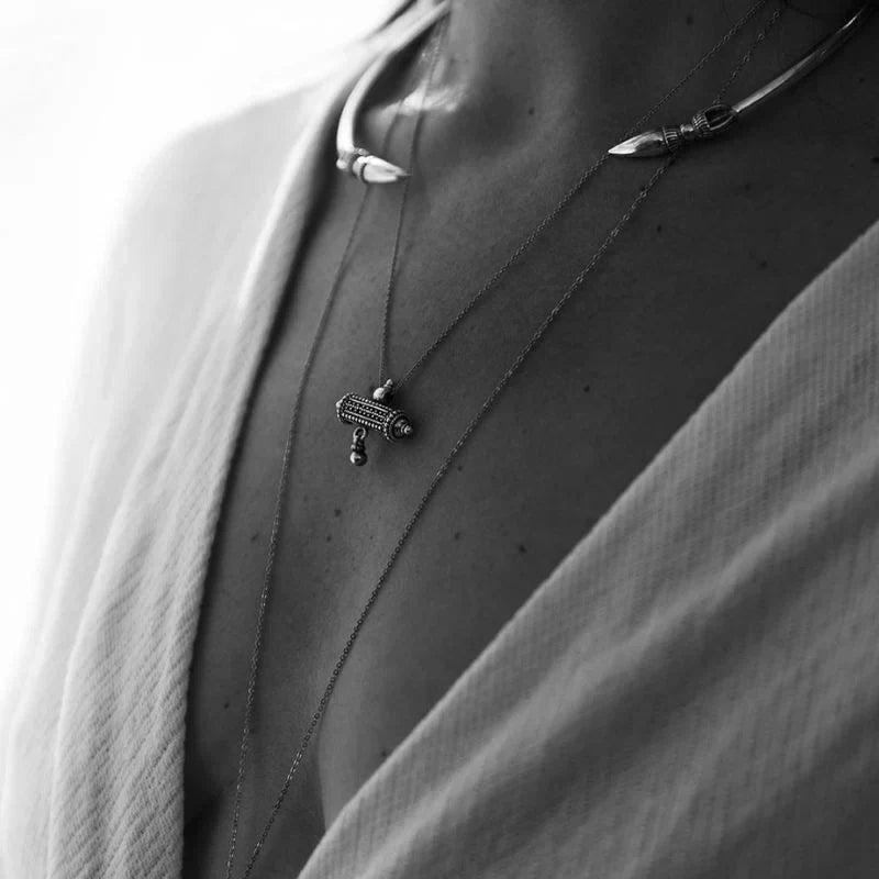 925 sterling silver barrel amulet pendant necklace on a fine chain, worn on a model at the 20-inch drop position against bare skin.