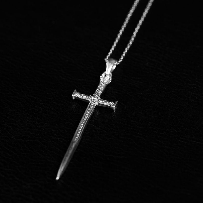 925 sterling silver sword pendant with a granulated blade and crossguard, hanging point-down from a fine chain.